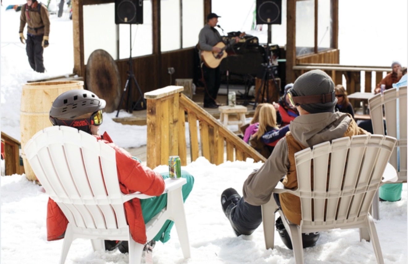 Live music on the Snow Beach deck at Gorrono Ranch, guests watching from chairs in the snow