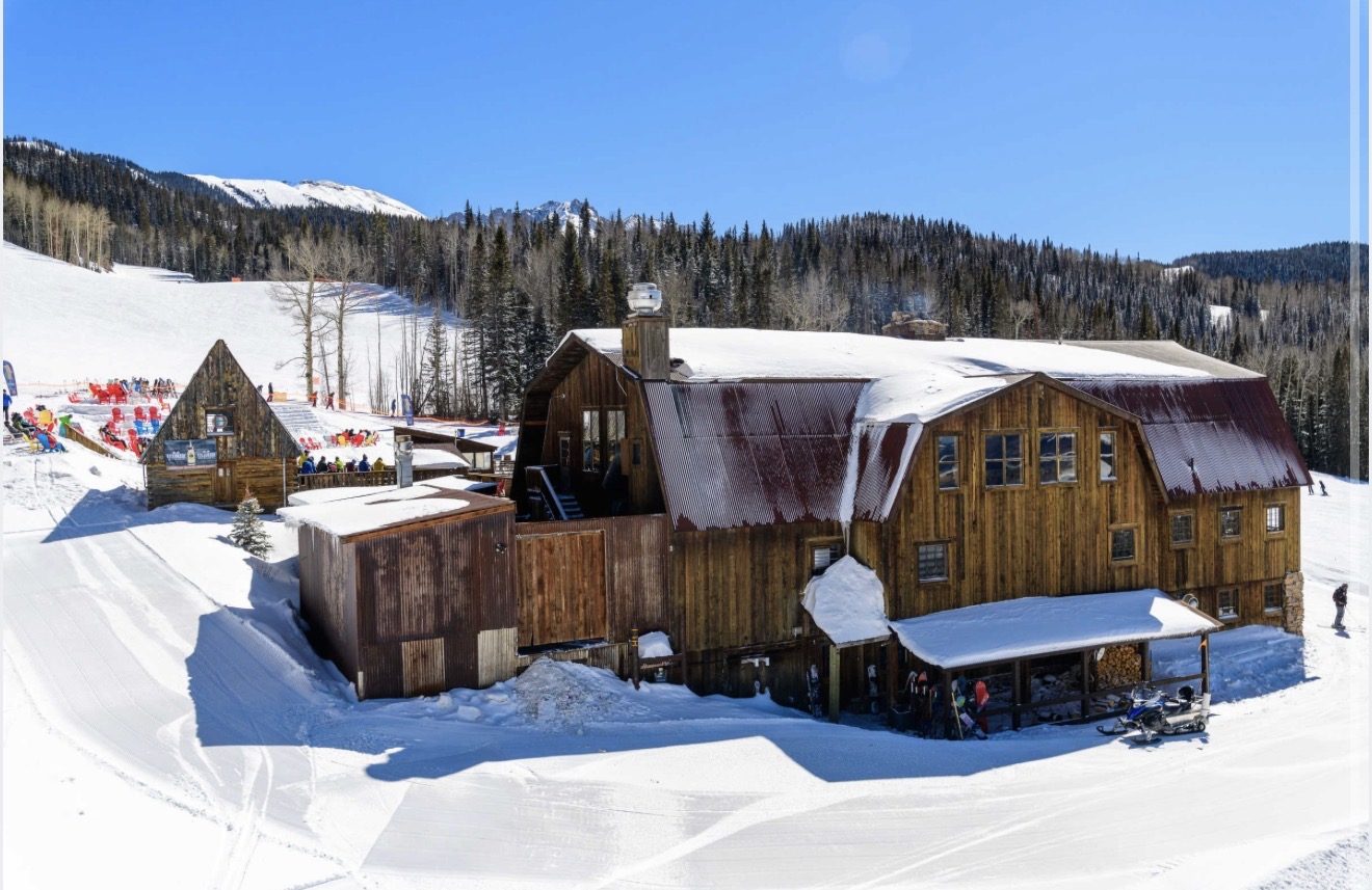 The historic timber buildings of Gorrono Ranch under snow at Telluride Ski Resort